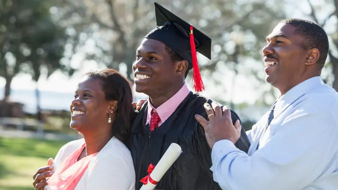 African American graduate (17 years) with proud parents (40s).