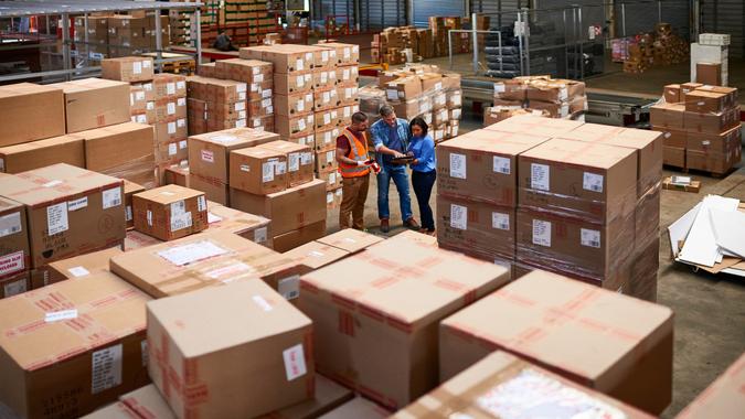 Shot of people at work in a large warehouse full of boxes.
