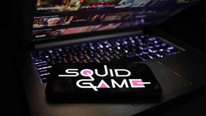 Mandatory Credit: Photo by Jakub Porzycki/NurPhoto/Shutterstock (12536579a)Squid Game series logo displayed on a phone screen and Netflix website displayed on a laptop screen are seen in this illustration photo taken in Krakow, Poland on October 13, 2021.