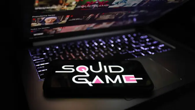 Mandatory Credit: Photo by Jakub Porzycki/NurPhoto/Shutterstock (12536579a)Squid Game series logo displayed on a phone screen and Netflix website displayed on a laptop screen are seen in this illustration photo taken in Krakow, Poland on October 13, 2021.