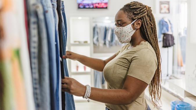 Covid-19: Woman customer choosing clothes at the mall store stock photo