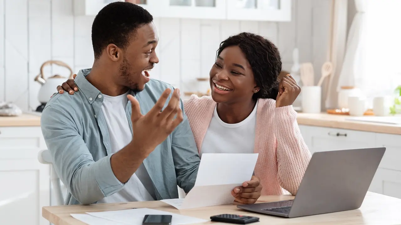Portrait Of Happy Excited Black Married Couple Reading Insurance Documents In Kitchen stock photo