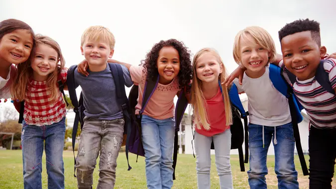 Portrait Of Excited Elementary School Pupils On Playing Field At Break Time.
