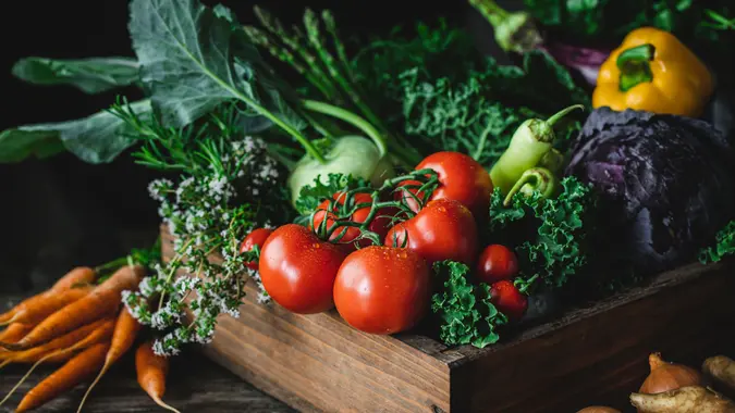 Top view of fresh organic vegetables in a wooden box.