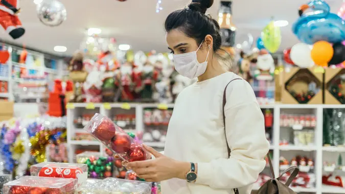 Woman wearing protective face mask and looking at a christmas market stall.