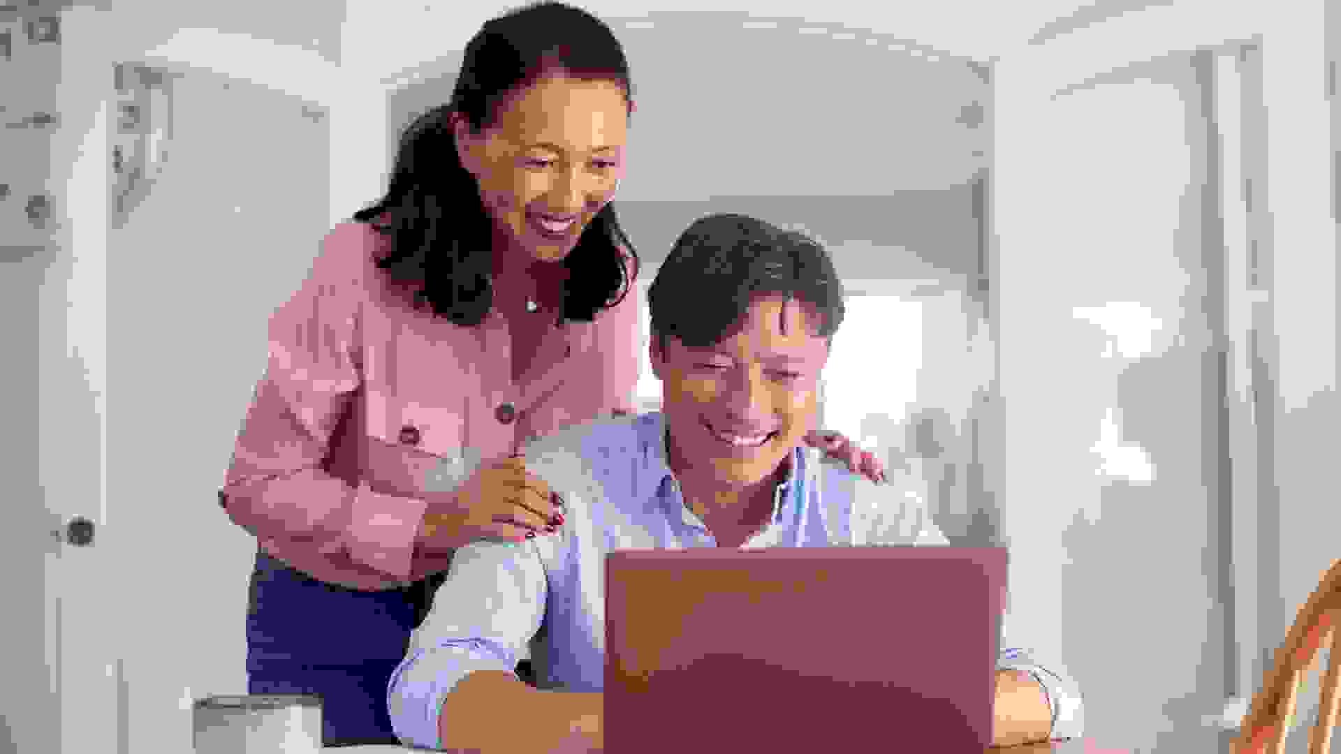 Mature Asian Couple At Home Using Laptop To Organise Household Bills And Finances.