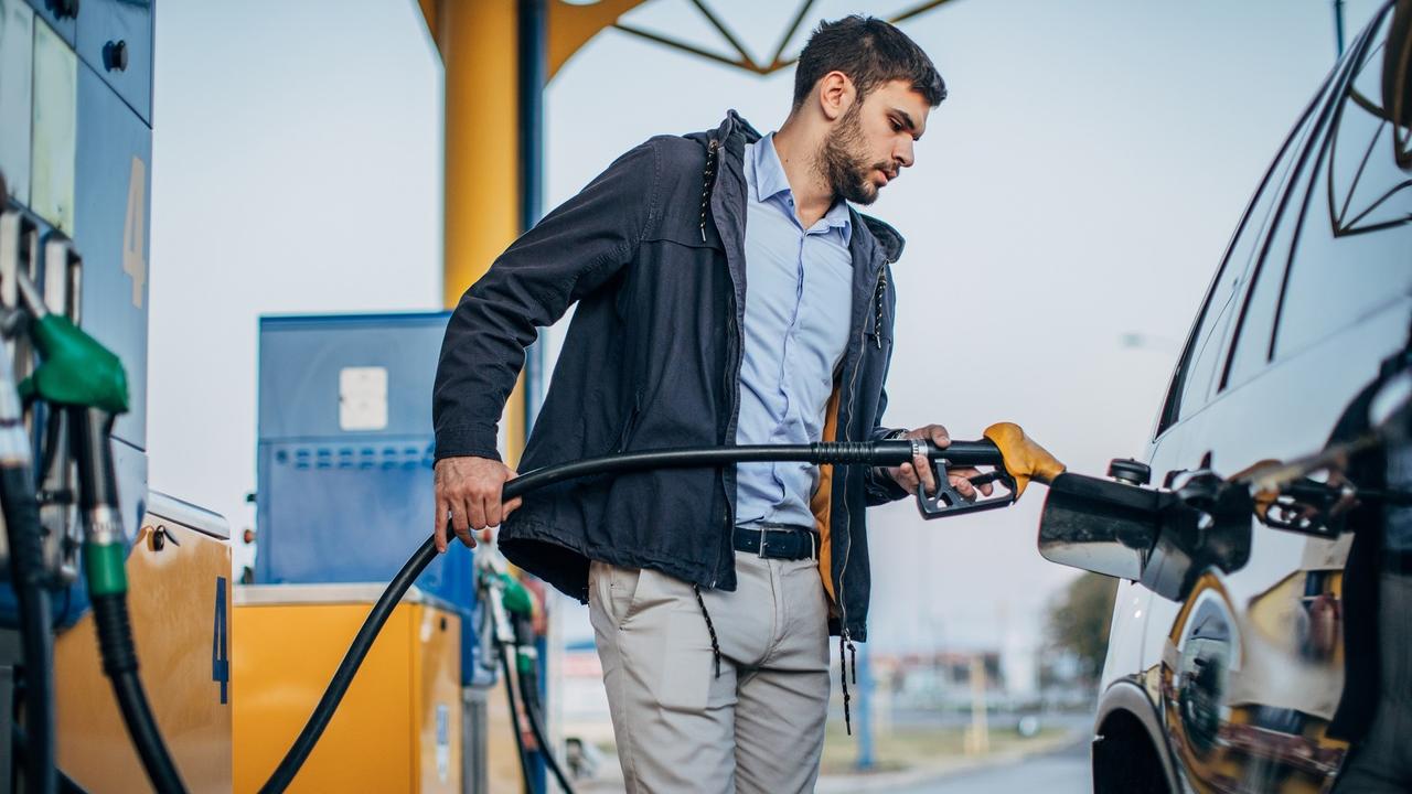 Guy pouring fuel in vehicle at the gas station stock photo