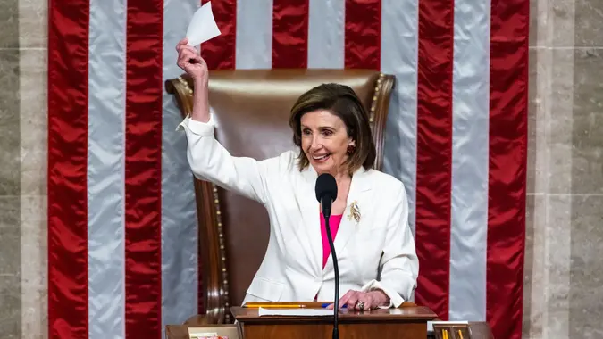 Mandatory Credit: Photo by JIM LO SCALZO/EPA-EFE/Shutterstock (12609872b)Speaker of the House Nancy Pelosi waves the vote tally after the House passed President Biden?s Build Back Better bill in the US House of Representatives in Washington, DC, USA, 19 November 2021.