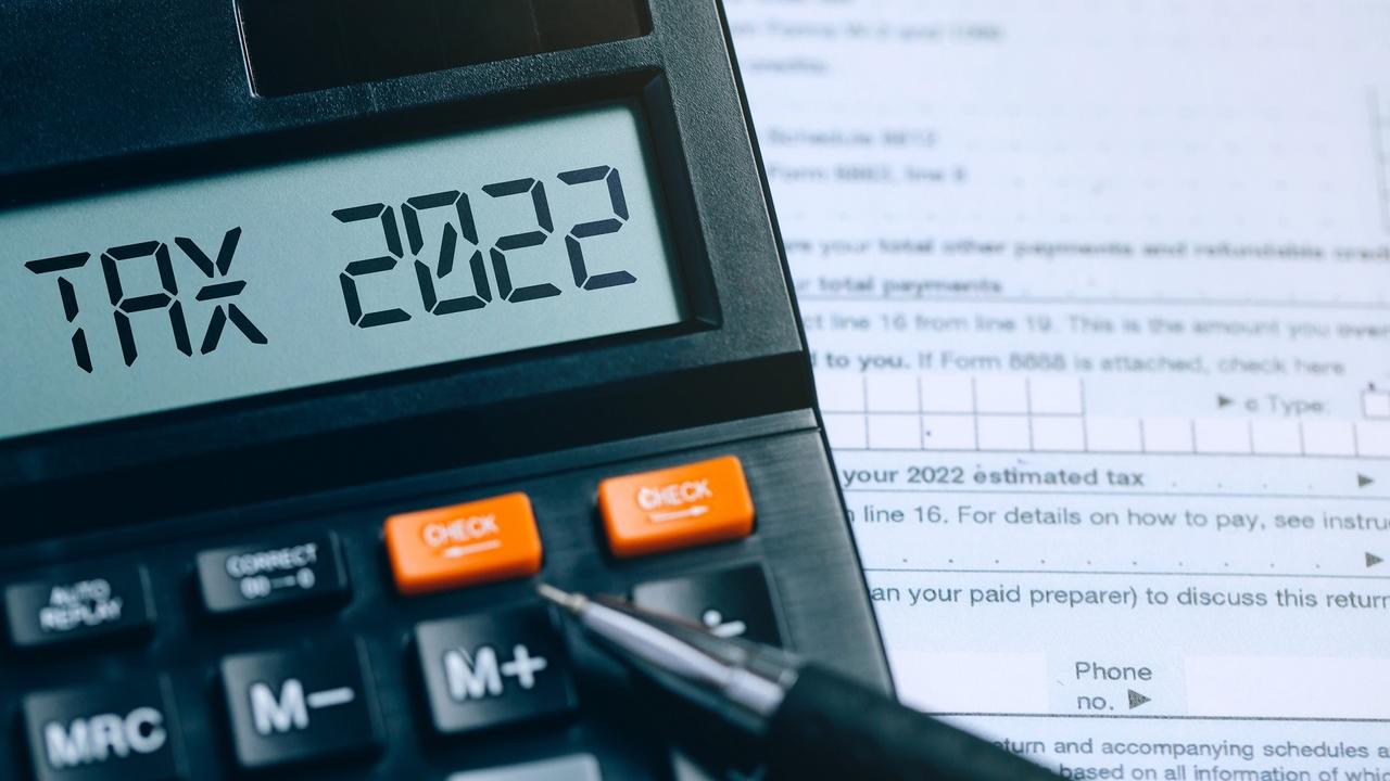 Word Tax 2022 on the calculator on documents.Income Statement. paying the tax rate. Taxation, taxes burden.Business and tax concept. stock photo
