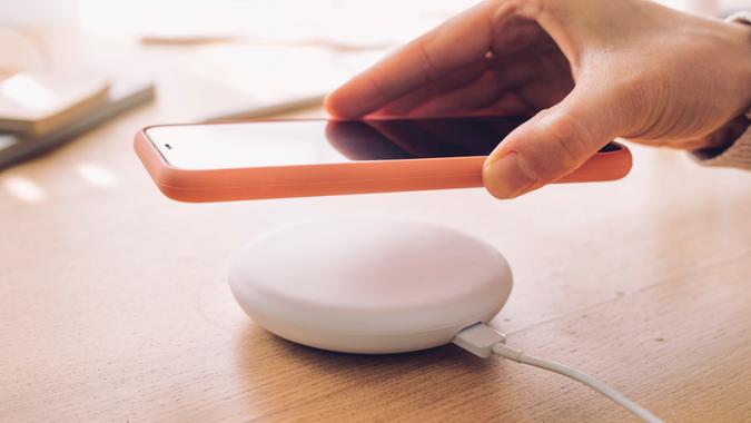 Wireless charging: a mobile phone being placed on a modern wireless power bank.