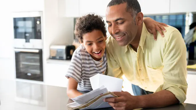 Happy father and son checking their mail at home stock photo