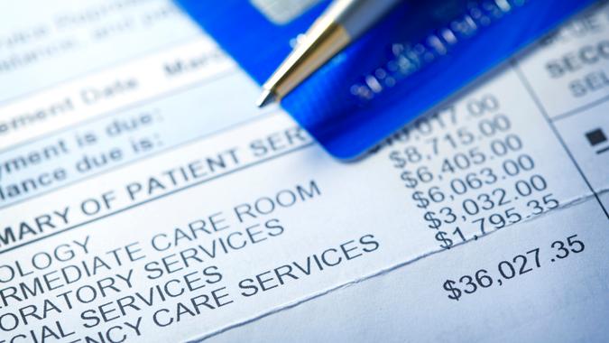 A hospital bill for $36,000 with a line item of various charges is photographed with a very shallow depth of field.