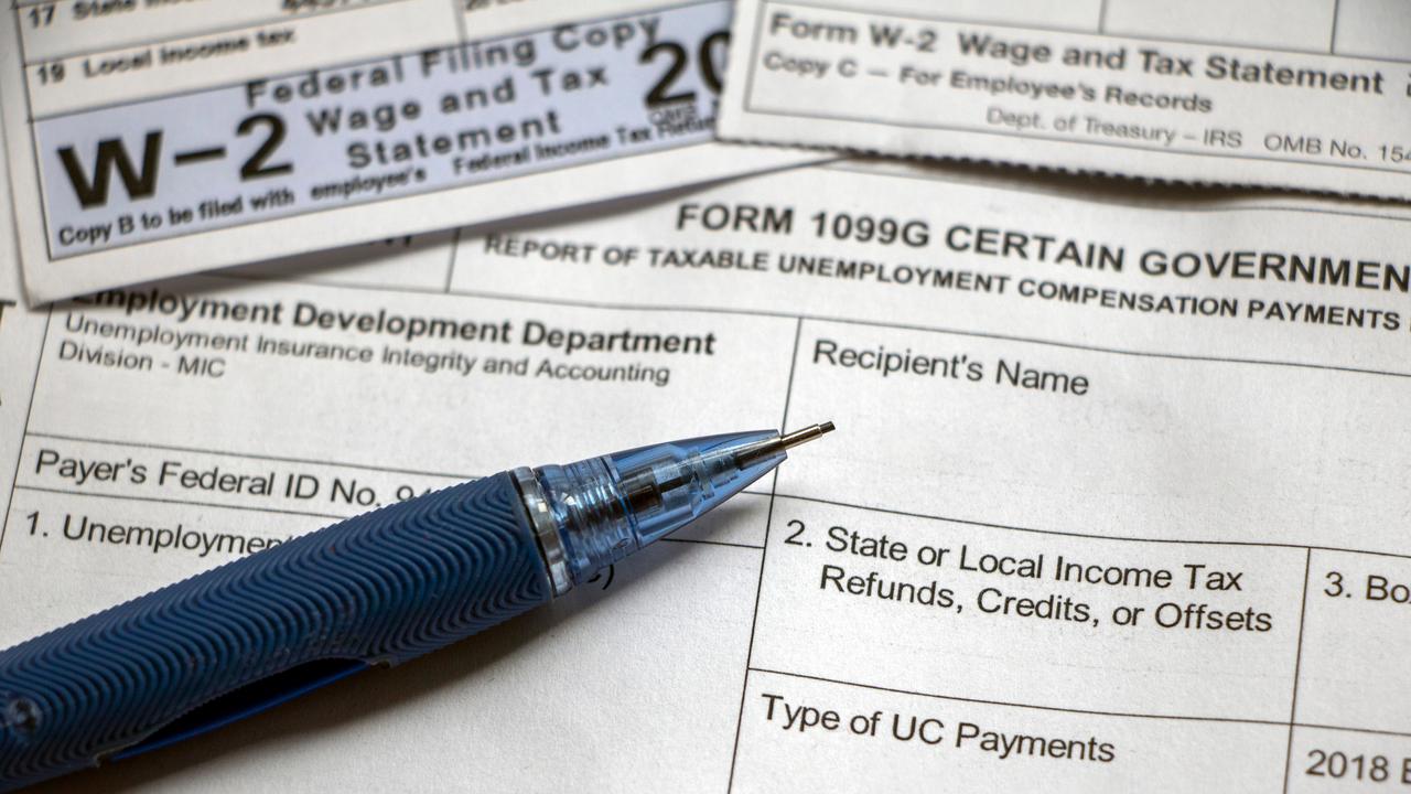 Closeup of a pencil laying on top of overlapping Form 1099G Certain Government Payouts and W-2 forms.
