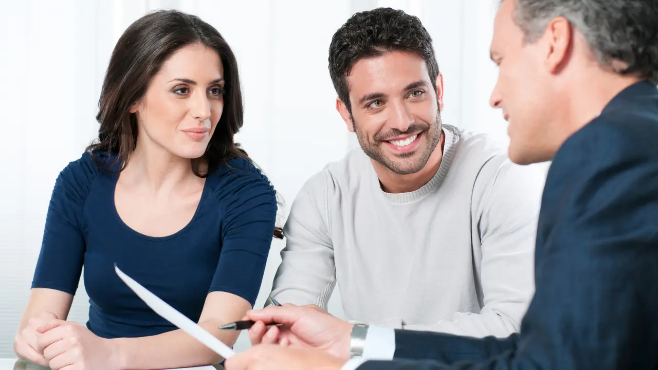 Financial consultant presents bank investments to a young couple.