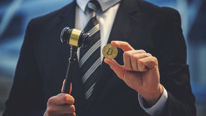 Bitcoin and judge gavel in hand stock photo