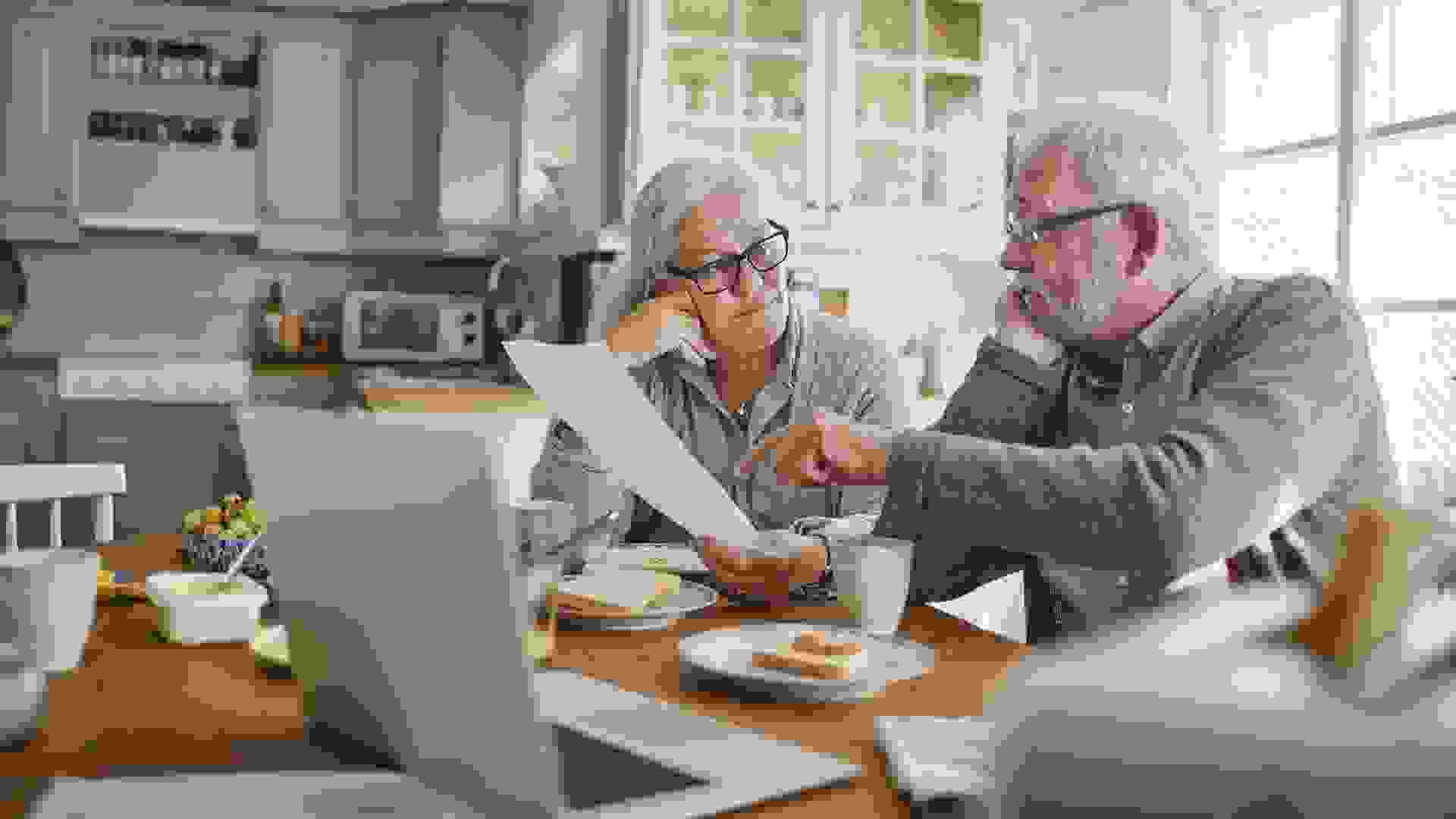 Senior couple having breakfast and doing bills stock photo