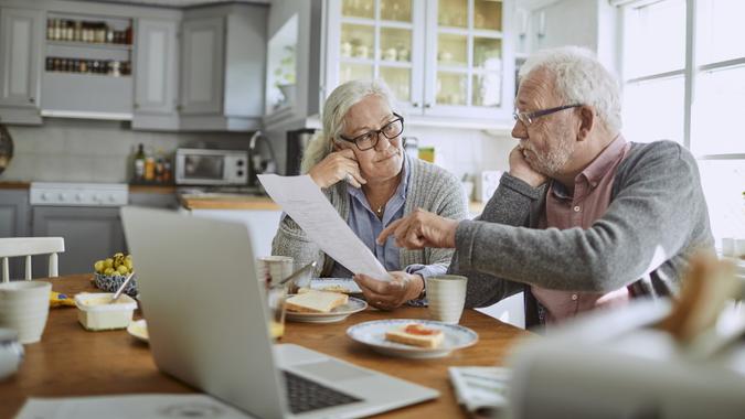 Senior couple having breakfast and doing bills stock photo