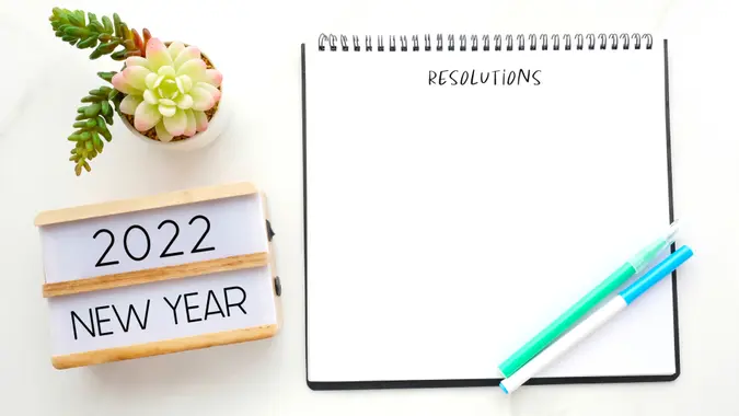 2022 new year on wood box, Resolution on blank notebook paper on white background, 2022 new year mock up, template, flat lay.