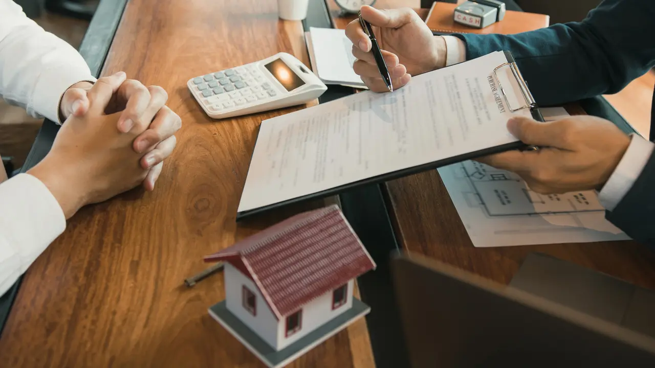 Agents are using pens pointing to contracts and are being explained to customers at the office.