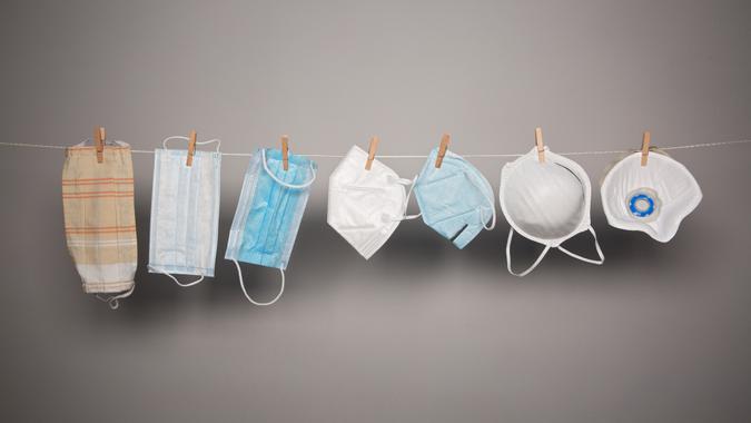 verschiedene Atemschutzmasken hängen auf Wäscheleine.