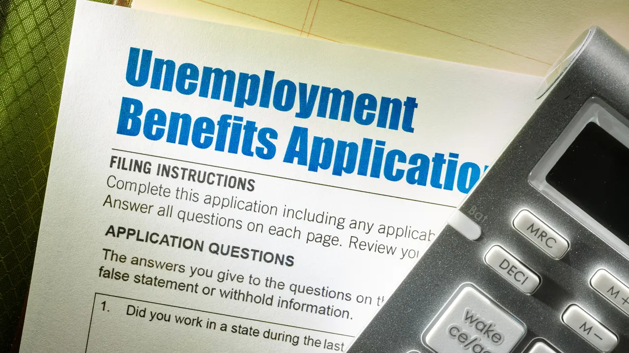 Unemployment Benefits Application with calculator on note pad.