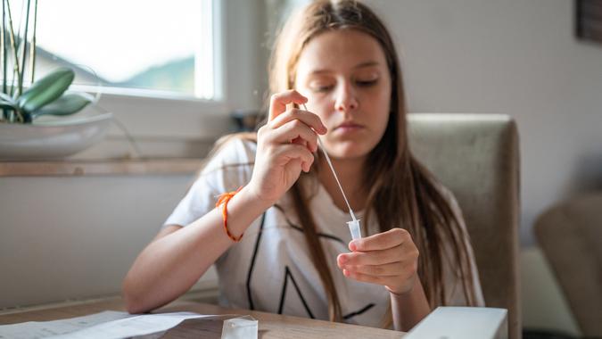 Young school girl doing a Covid self-test at home.