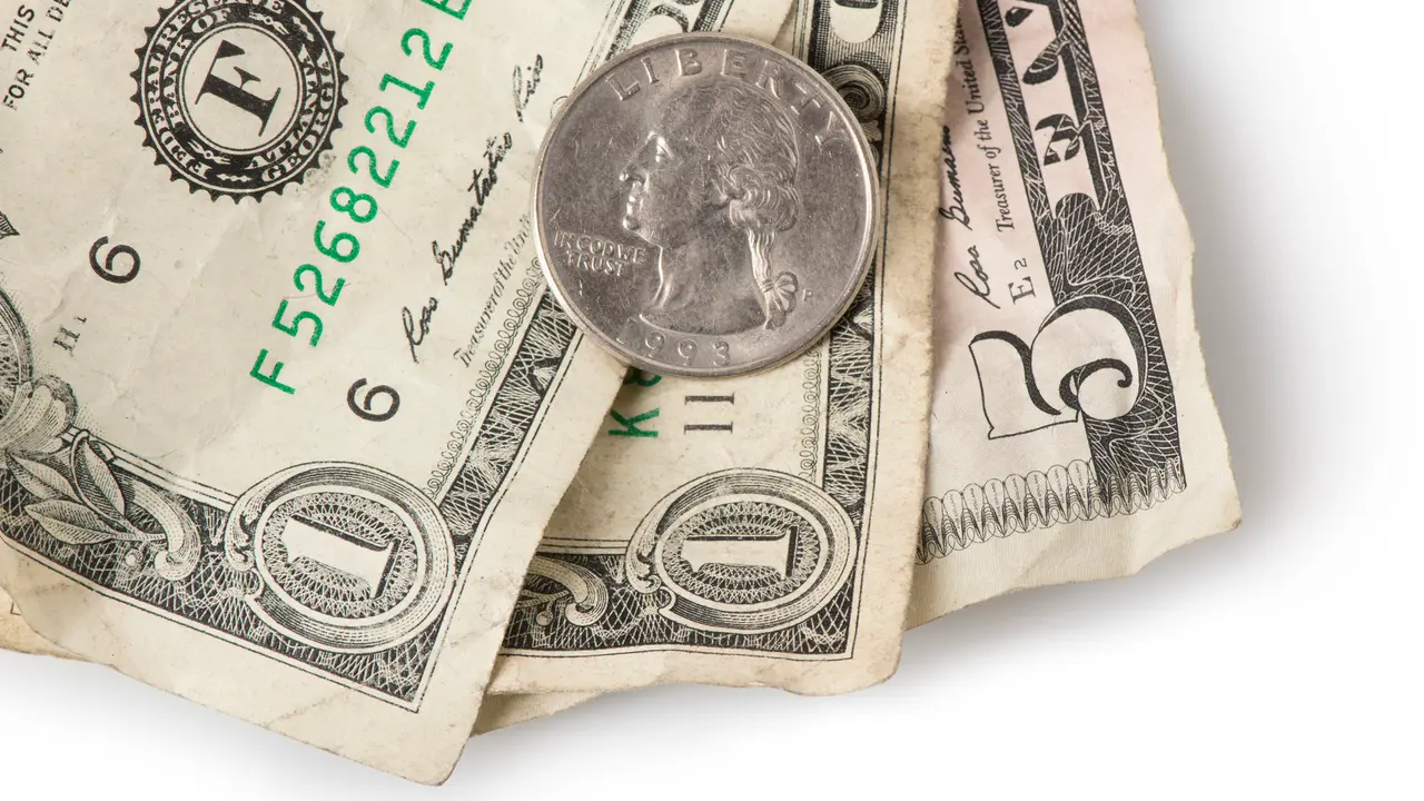 Wrinkled dollar bills and a quarter adding up to $7.