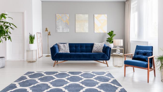 Open space living room interior with a navy blue sofa and an armchair.