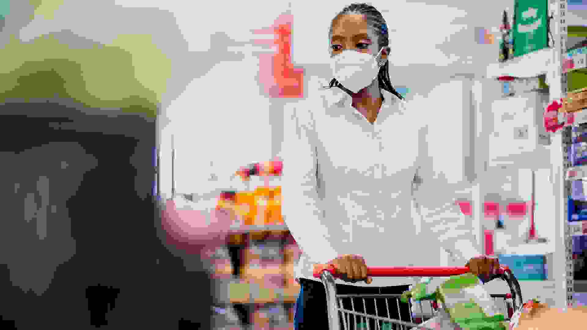Woman shopping in supermarket wearing coronavirus face mask. stock photo