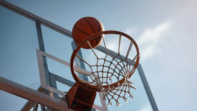 Closeup shot of a basketball landing into a net on a sports court.