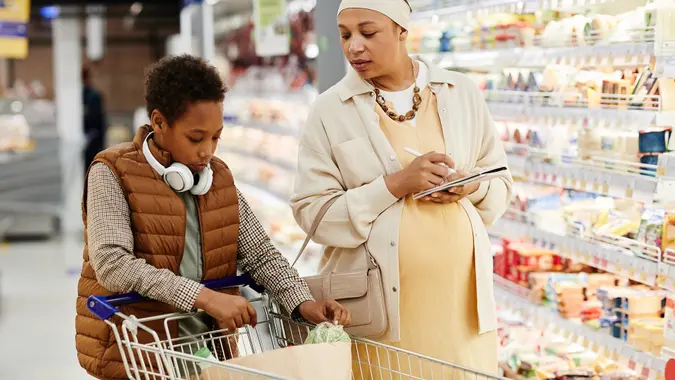 African American Woman Grocery Shopping with Son stock photo