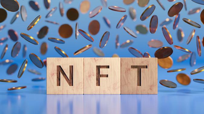 NFT word in front of falling coins background.  archive image
