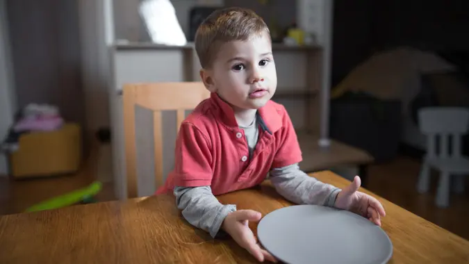 Cute little hungry boy waiting for his dinner.