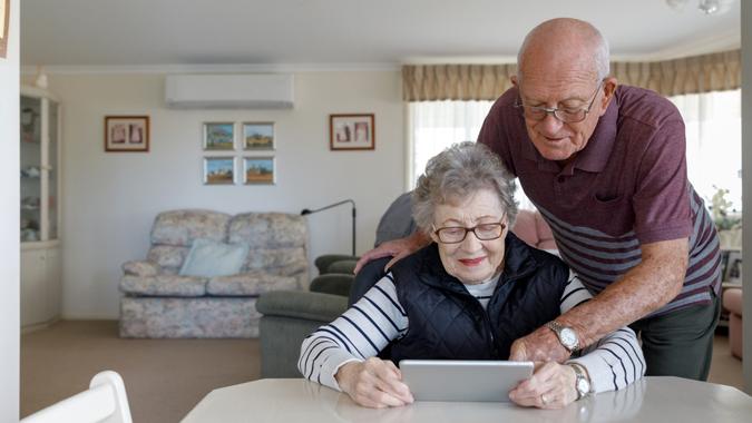 Senior Australian Couple Learning To Use Digital Tablet While Living Independently In Their Own Home.