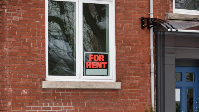 A for rent sign in the window of a House.