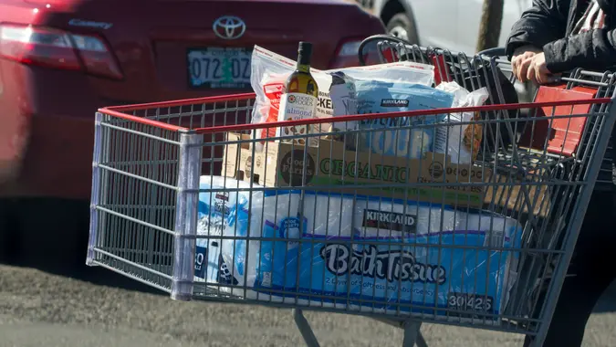 Tigard, OR, USA - Mar 17, 2020: A shopper pushing a cart loaded with bath tissues and other groceries at a Costco Wholesale Store in Tigard, Oregon.