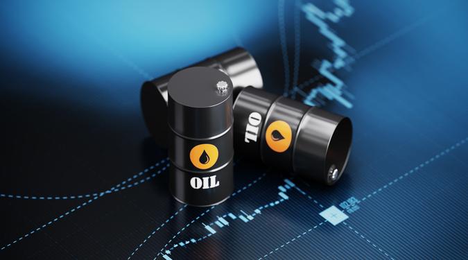 Oil drums sitting over blue financial graph background.