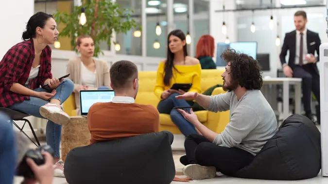 business people group in modern office have a team meeting and brainstorming while working on tablet or laptop presenting ideas and take notes.
