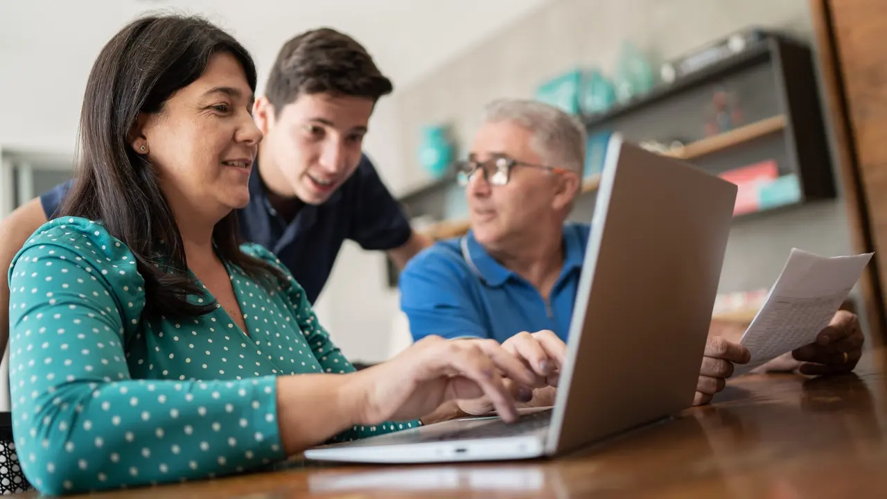 Parents doing home finances and talking to teenager son stock photo