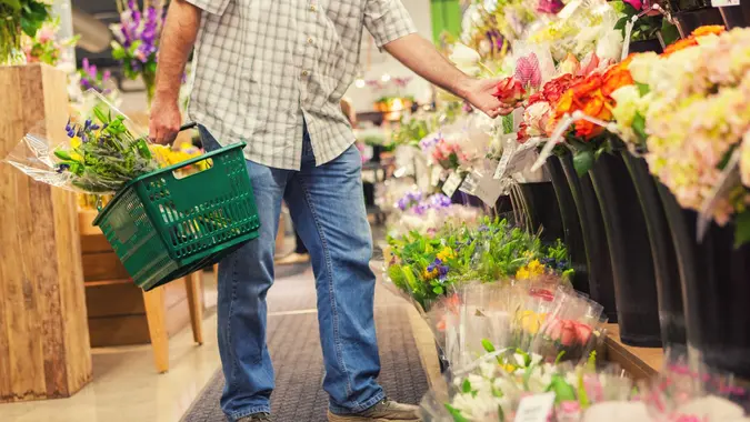 Male customer chooses fresh flowers in market stock photo