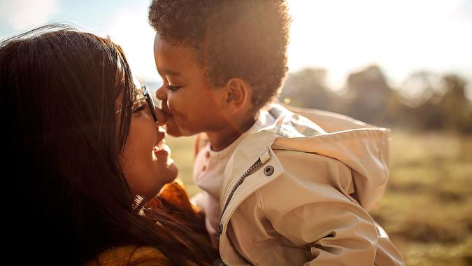 Multi-ethic mother and son spending time together outdoors stock photo
