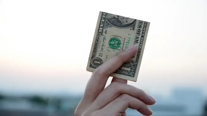 holding one dollar.