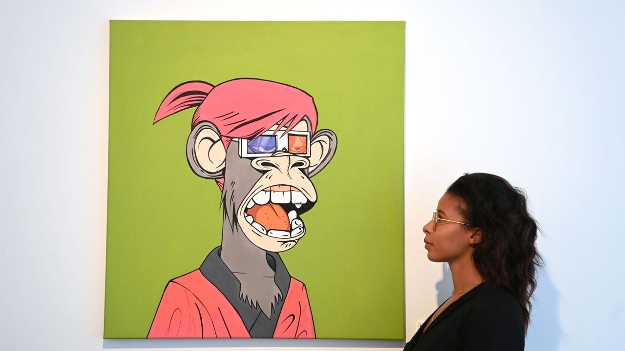 Mandatory Credit: Photo by FACUNDO ARRIZABALAGA/EPA-EFE/Shutterstock (12457855i)A gallery employee poses for photographers next to an artwork titled 'BORED APE YACHT CLUB' during the press view of 'Portrait of an era' NTF (Non fungible token) exhibition at the HOFA (House of Fine Arts) gallery in London, Britain 22 September 2021.