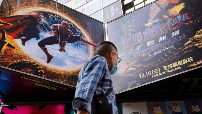 Mandatory Credit: Photo by Budrul Chukrut/SOPA Images/Shutterstock (12657069a)A pedestrian walks past an advertisement billboard from Marvel comics character Spider-Man "No Way Home movie, co-produced by Columbia Pictures and distributed by distributed by Sony Pictures, is being displayed above him in Hong Kong.