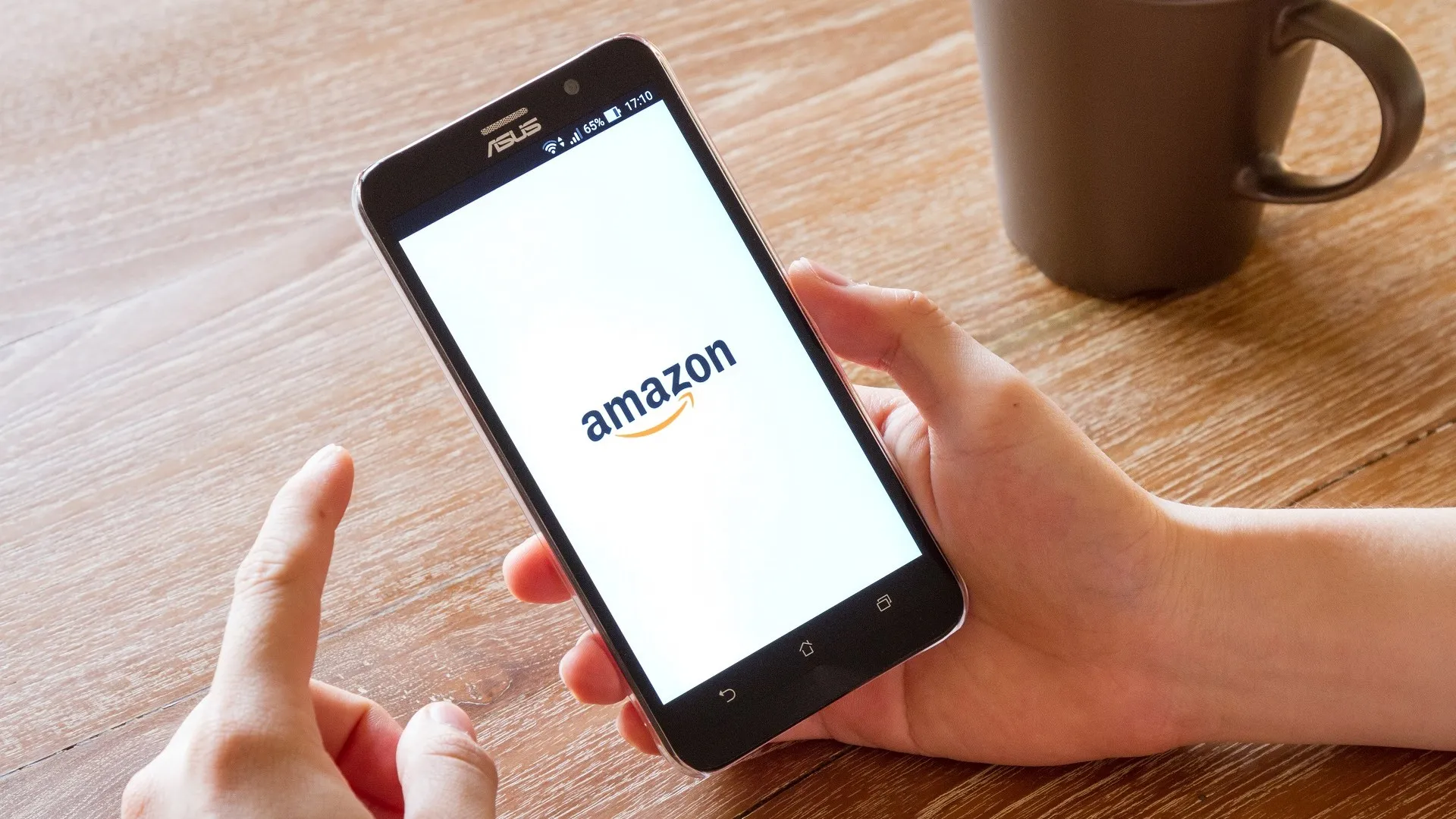 Man hand holding screen shot of Amazon application stock photo