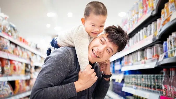 Asian father and son having fun shopping in a supermarket stock photo