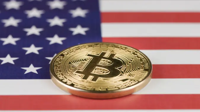 Slovenia, Ljubljana - 11 11 2019: Golden cryptocurrency Bitcoin on flag of United States of America, USA.