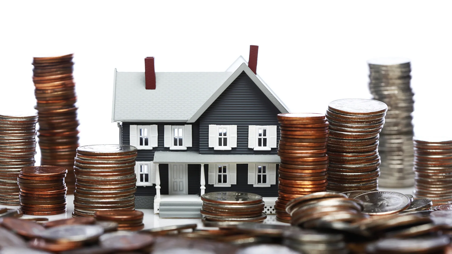 "House Surrounded By Money, Coins, Pennies, Nickels, Dimes and Quarters on a White Background with Copy Space.