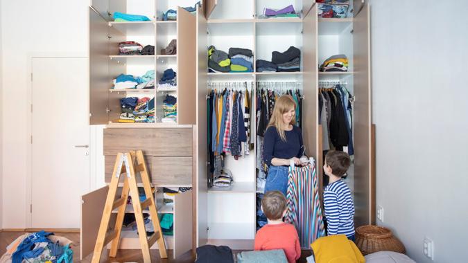Kids helping their mother to organize her wardrobe.