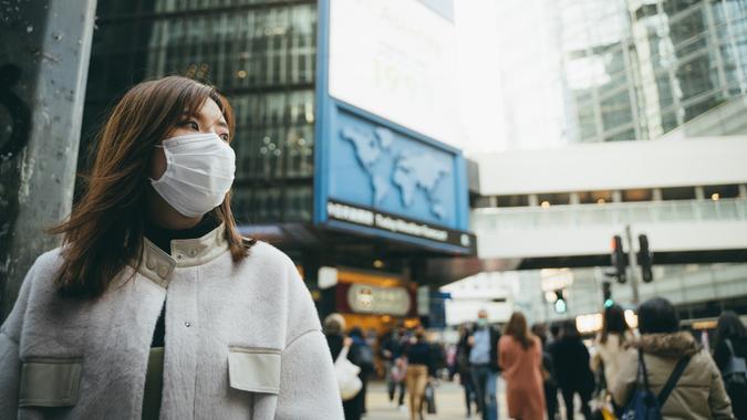 Young Asian woman wearing a protective face mask to prevent the spread of germs and viruses in the city stock photo
